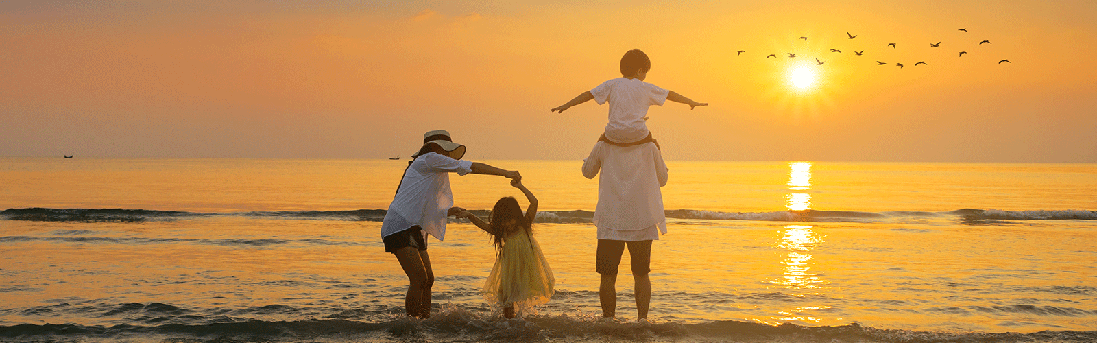 Family enjoying the beach at sunset. 