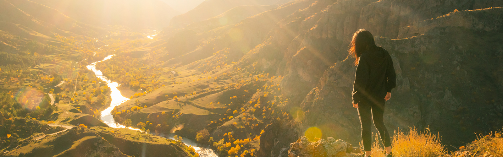 Hiker looking at valley from atop a mountain. 