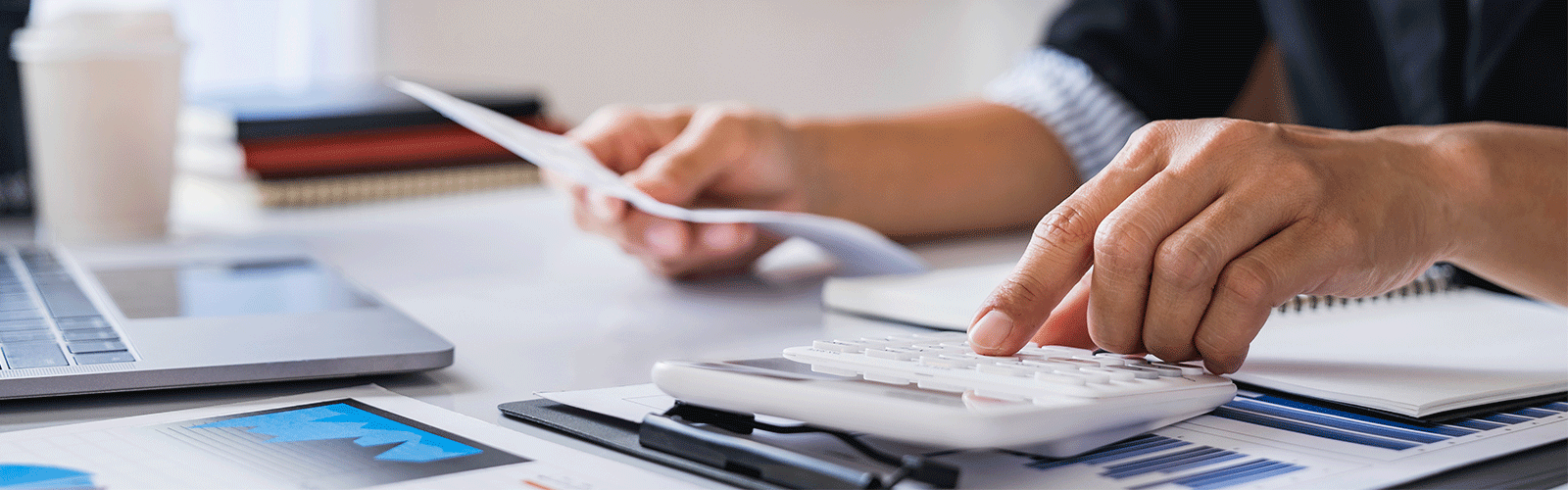 A member doing their taxes using a calculator. 