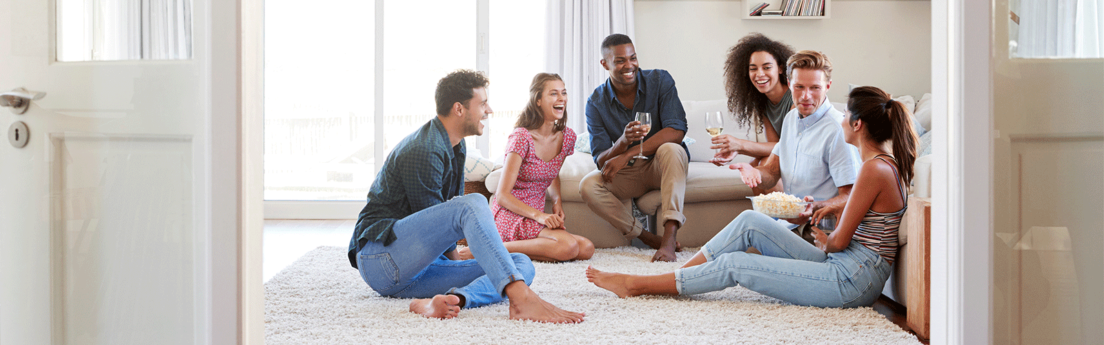 Three couples laughing on an evening in their manufactured home. 