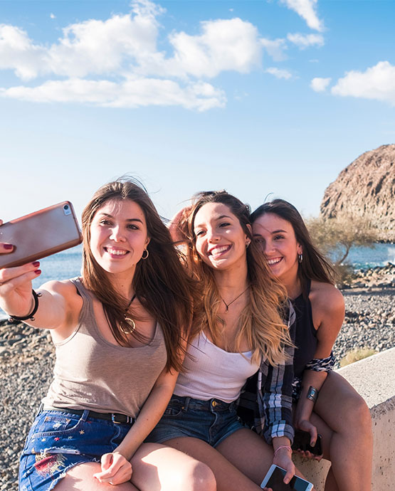 Three ladies on vacation taking a selfie. 
